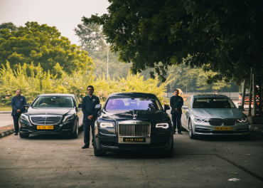 Professional chauffeur assisting a client into a luxury car outside a Chennai hotel.